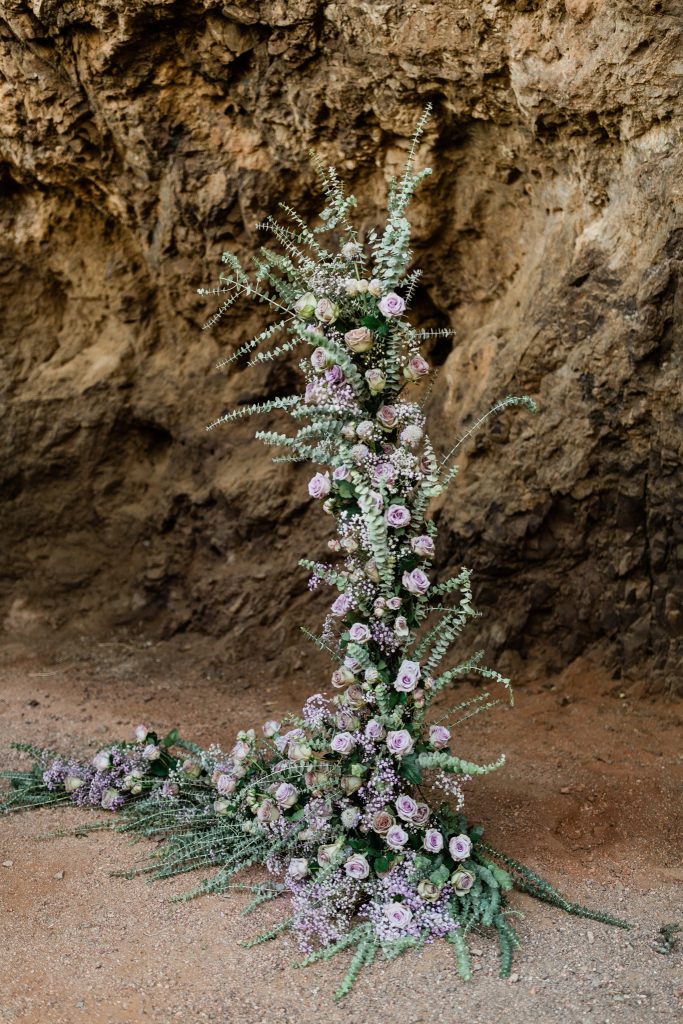 L shaped lavender rose and eucalyptus ground floral arrangement