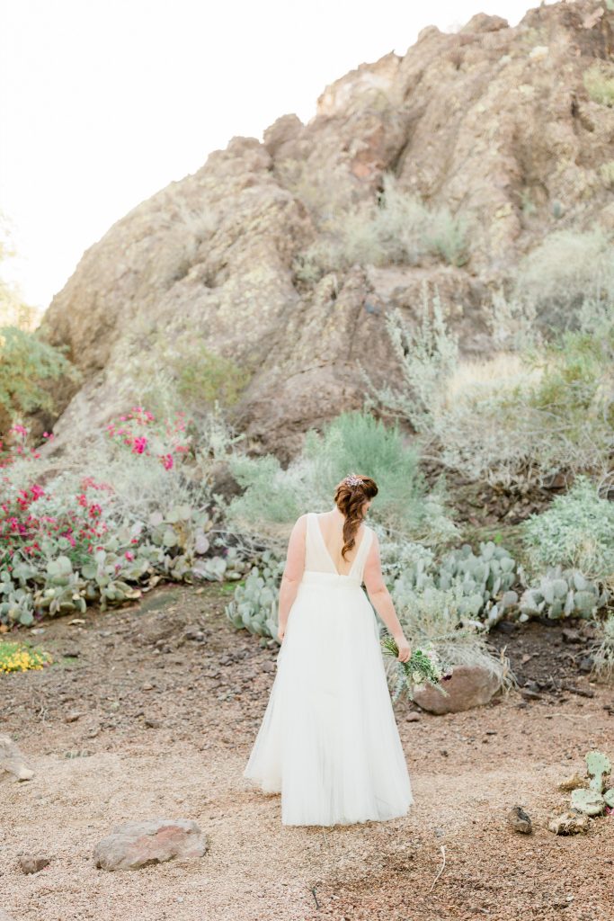 bride walking away holding a bouquet for a desert bridal session