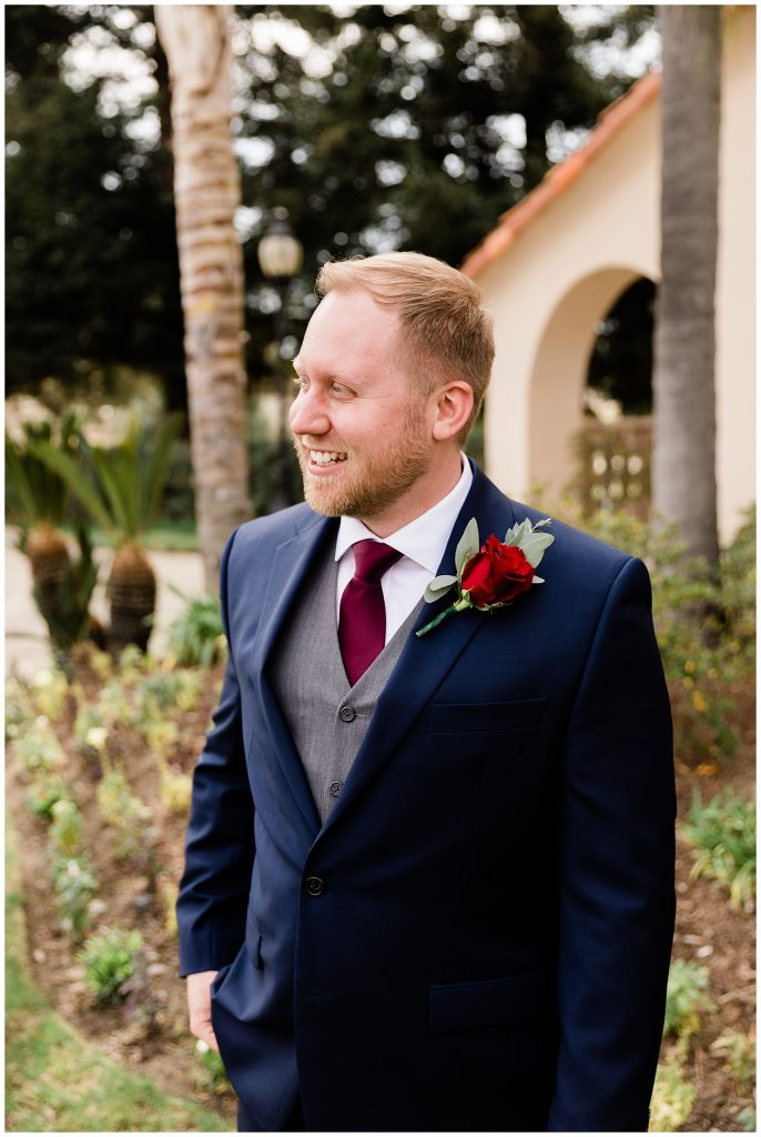 groom in navy suit with red boutonniere 