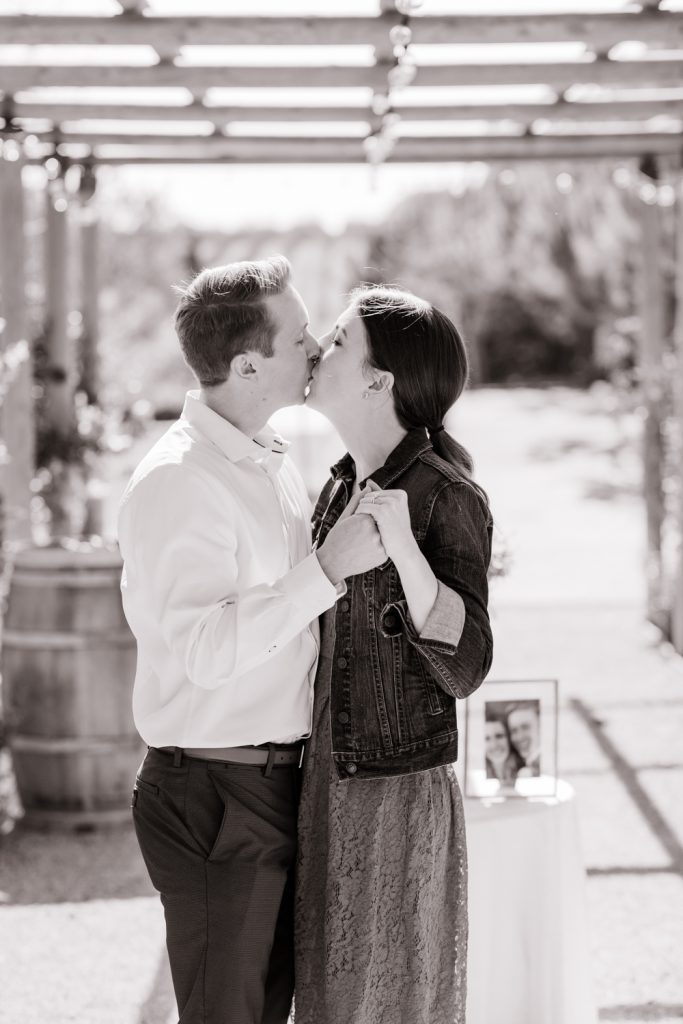 black and white edit of an engaged couple kissing after their proposal