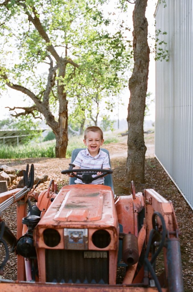 candid toddler having fun on a tractor