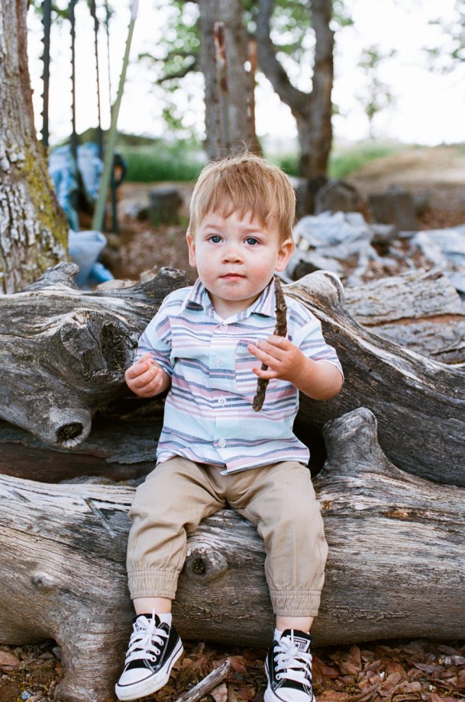 candid baby sitting on a log