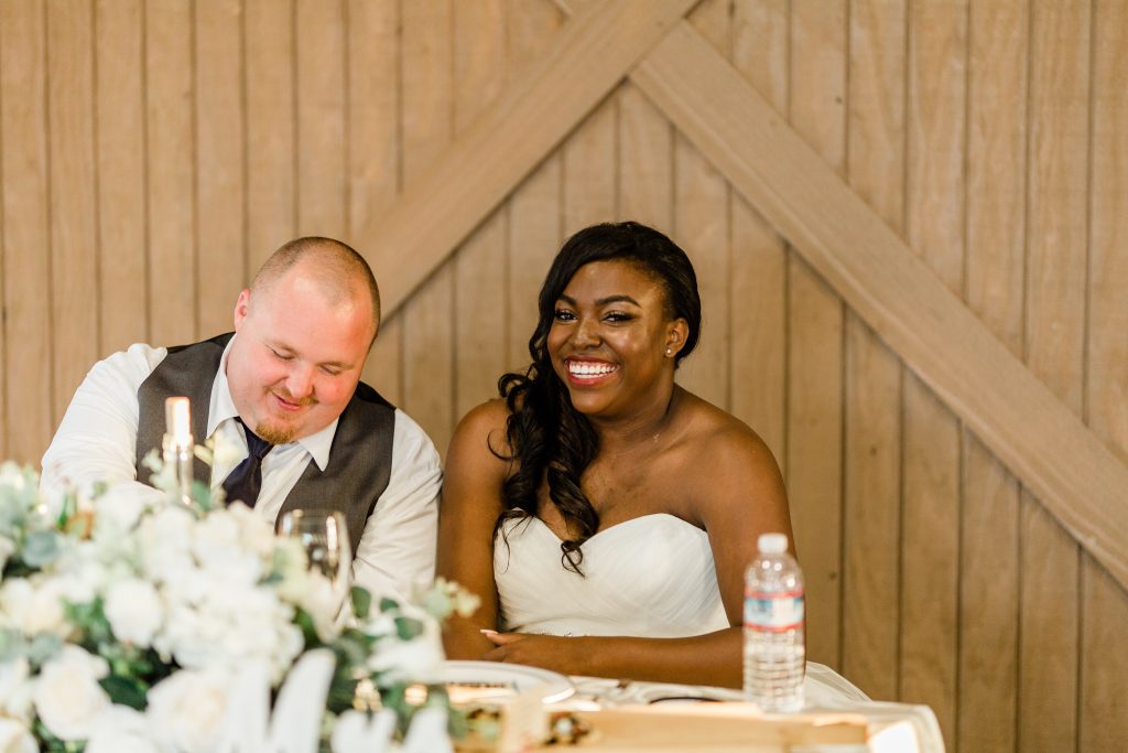 bride and groom laughing at head table
