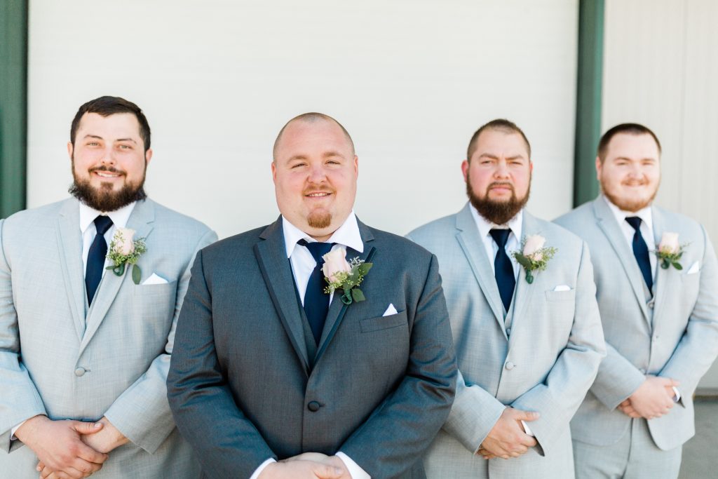 groom in charcoal and groomsmen in light grey with navy