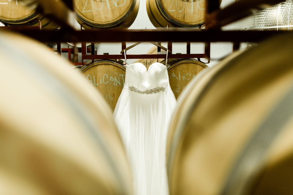 wedding dress hanging on wine barrels at Kings River Winery