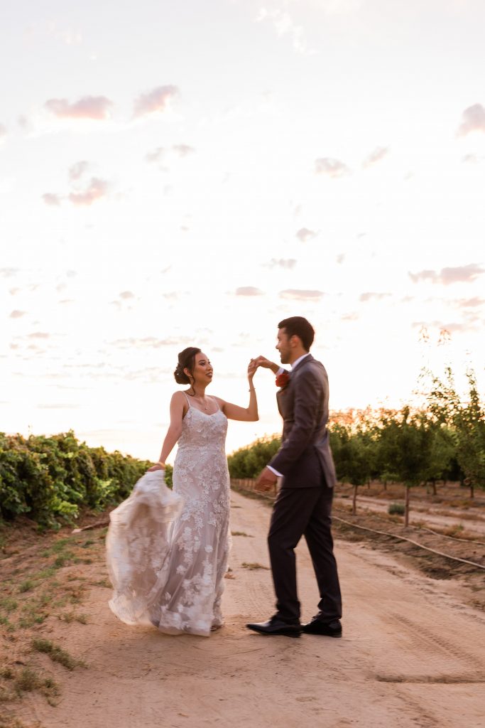 bride and groom dancing in a winery vineyard at sunset 