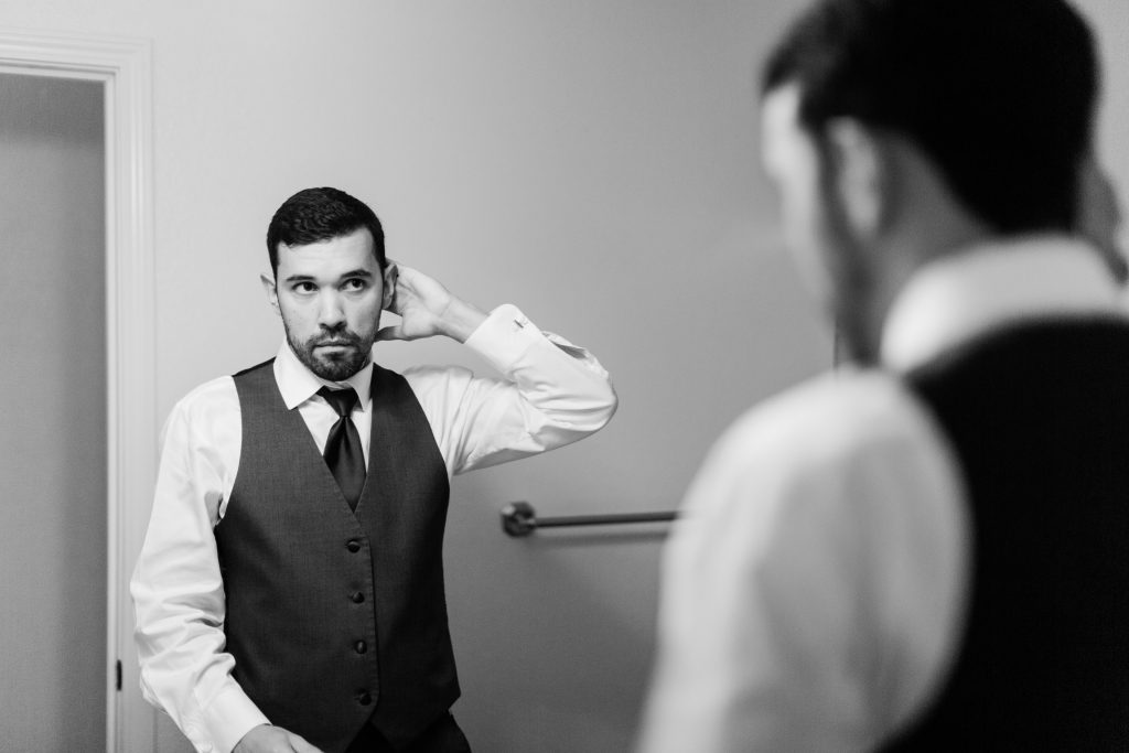 groom styling his hair in the mirror