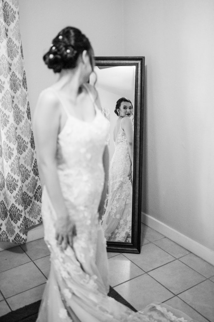 bride looking over her shoulder at her reflection in the mirror