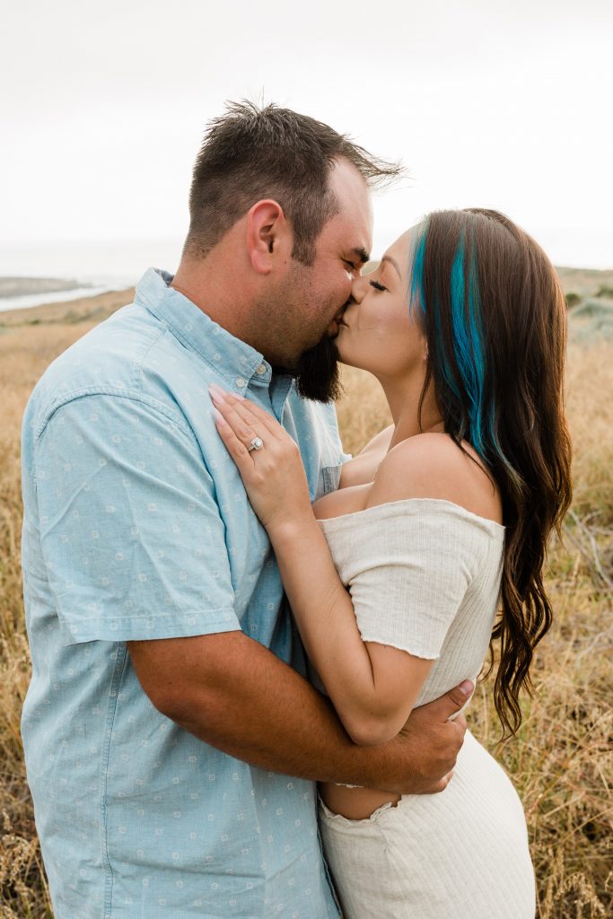 engaged couple kissing on the cliffs of montana de oro beach