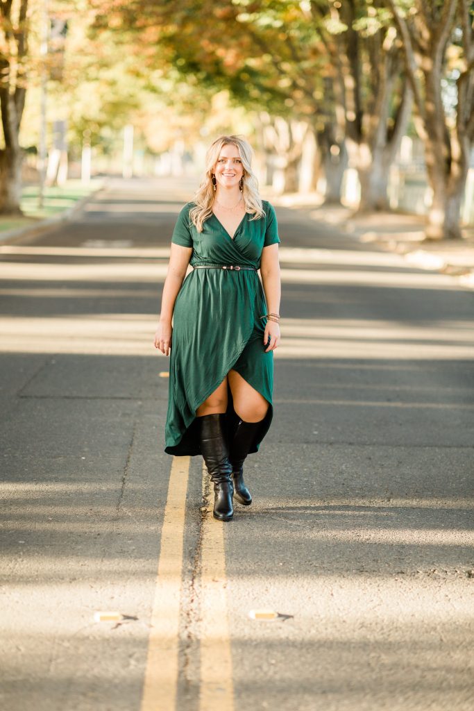 woman in high/low dress and boots on tree lined streets of sacramento state university