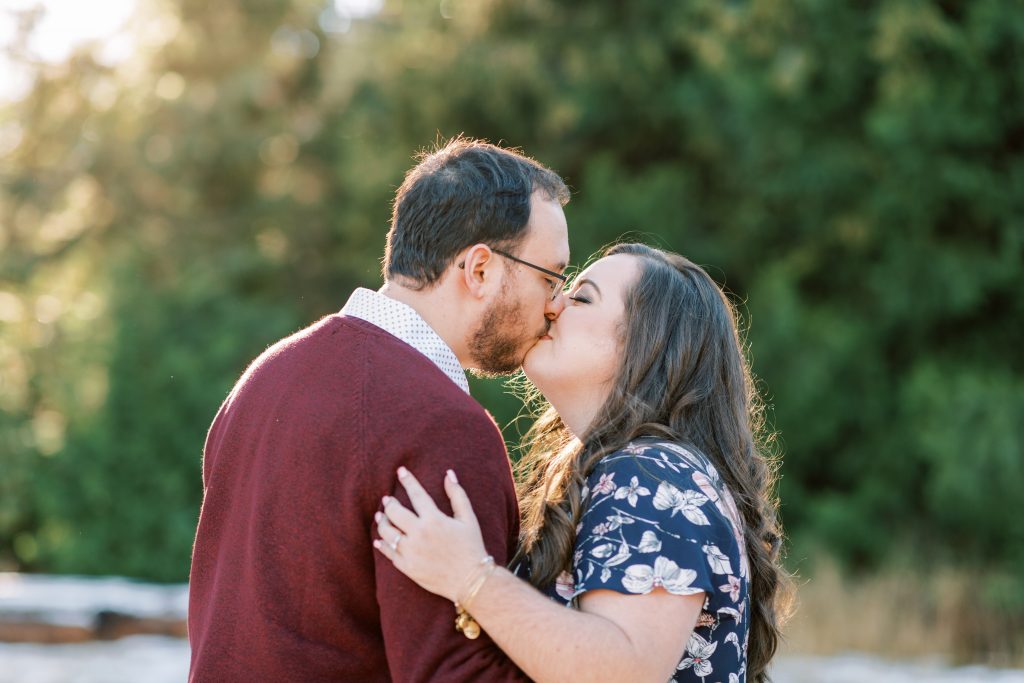engaged couple kissing during golden hour for a winter engagement session