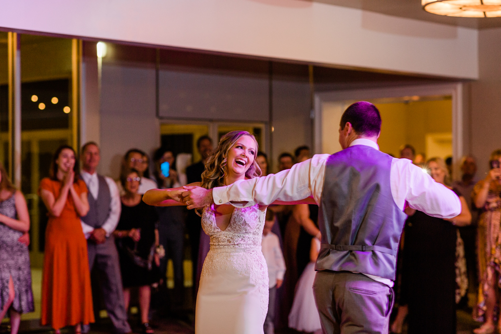 Bride laughing while she dances with groom