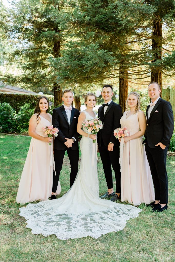 bridal party with blush bridesmaid dresses and black tuxedos at wolf lakes park in fresno