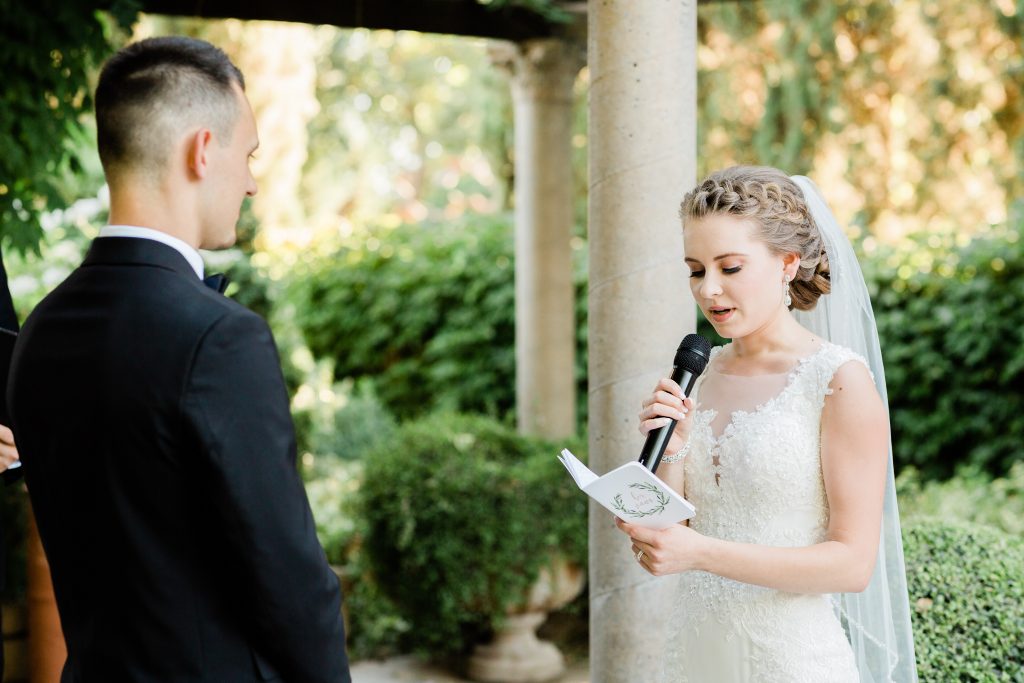 bride reading her wedding vows during a garden side wedding ceremony at wolf lakes park