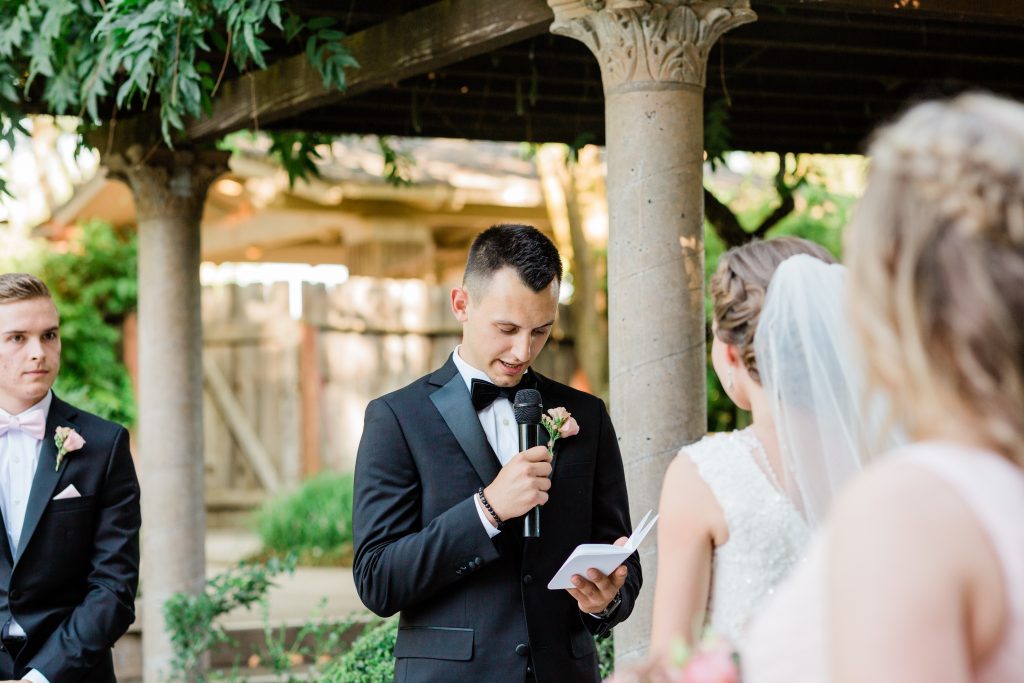 grooms reading his wedding vows during a garden side wedding ceremony at wolf lakes park