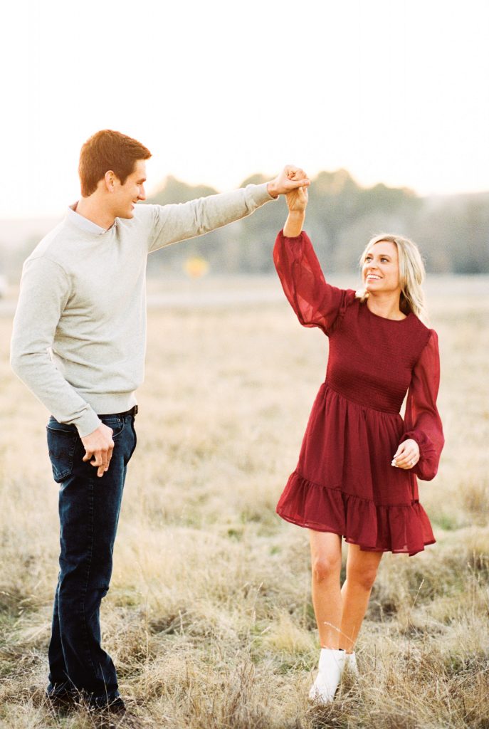fall engagement photo twirl in burgundy dress at Lost Lake