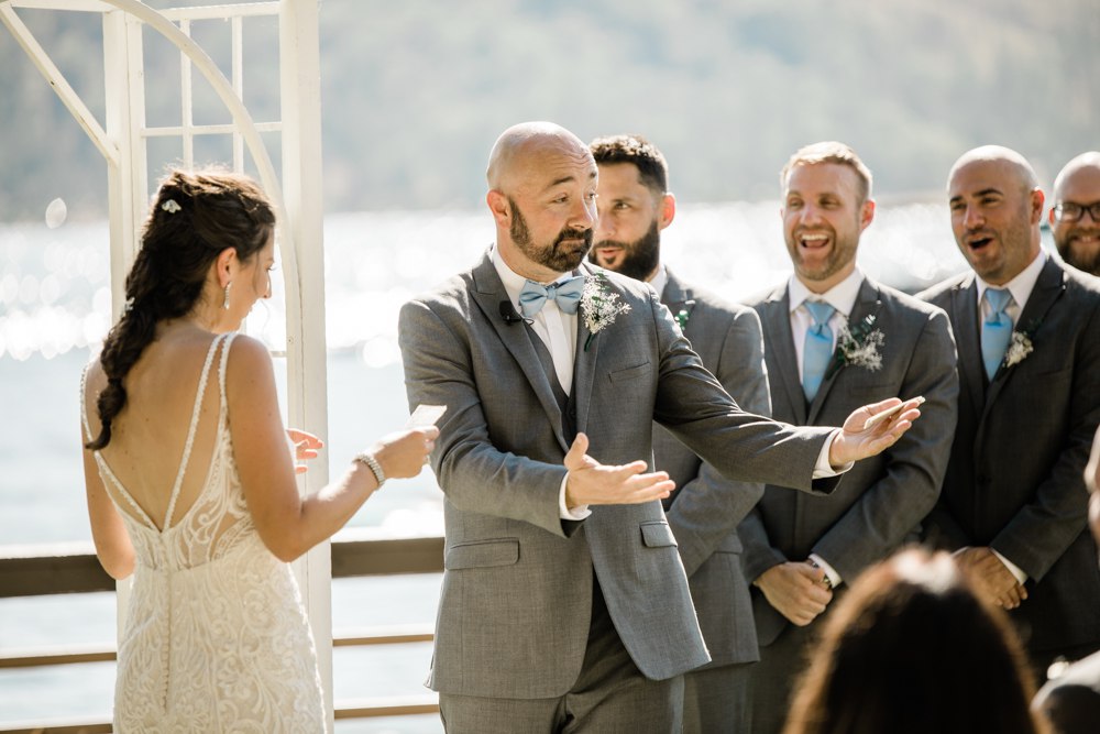 Groom and groomsmen laughing during brides vows