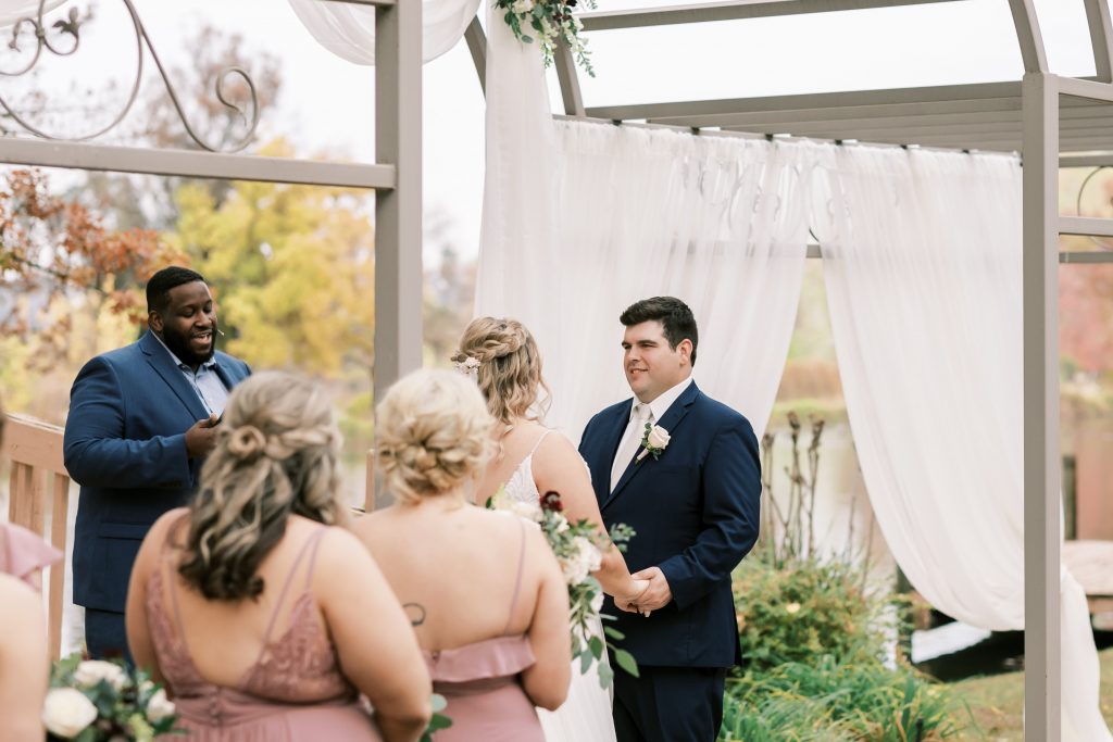Couple holding hands during outdoor wedding ceremony