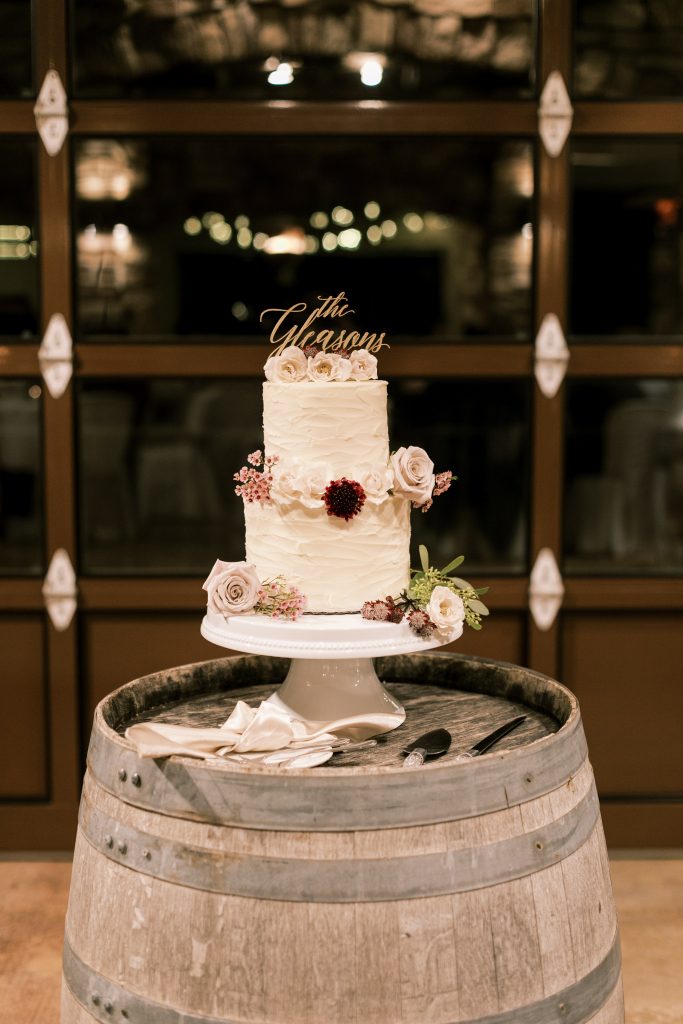 Two tier white wedding cake with blush and white flowers