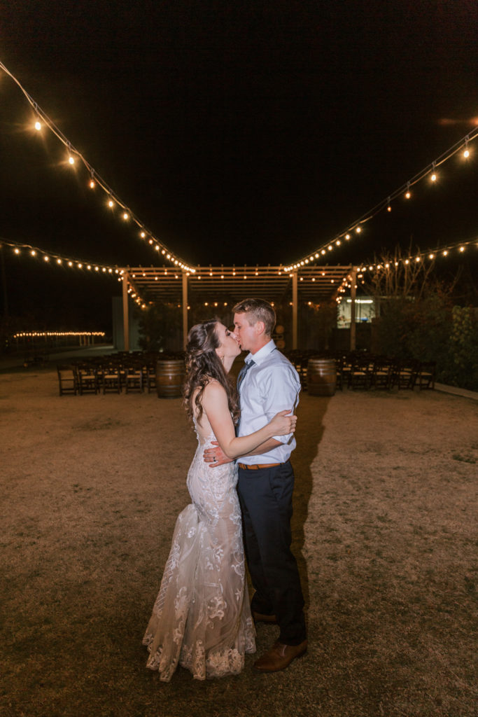 Newlyweds taking a moment outside under string lights at a Kings River Winery wedding