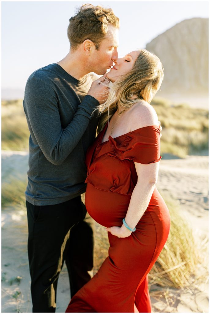 Husband pulling his pregnant wife up to kiss