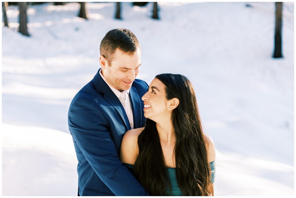 Engaged couple smiling while looking at each other