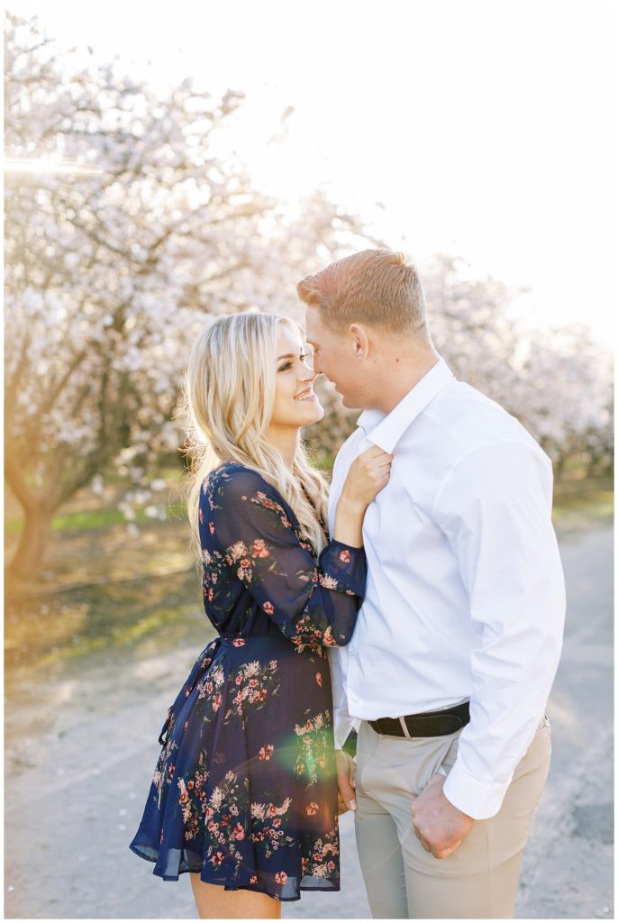 Fiance leaning in to kiss woman in blue floral dress