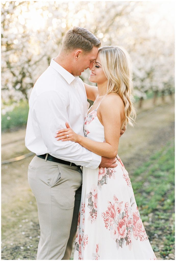 Film portrait of engaged couple with woman in a spring dress.