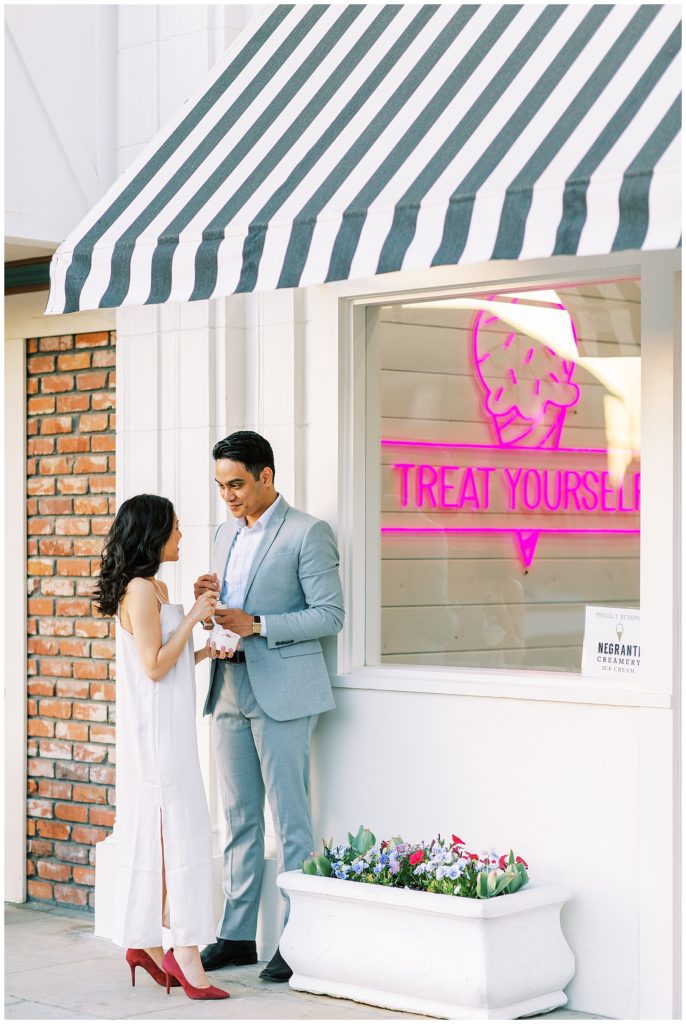 Engaged couple talking while eating Bella Creamery ice cream in downtown Kingsburg