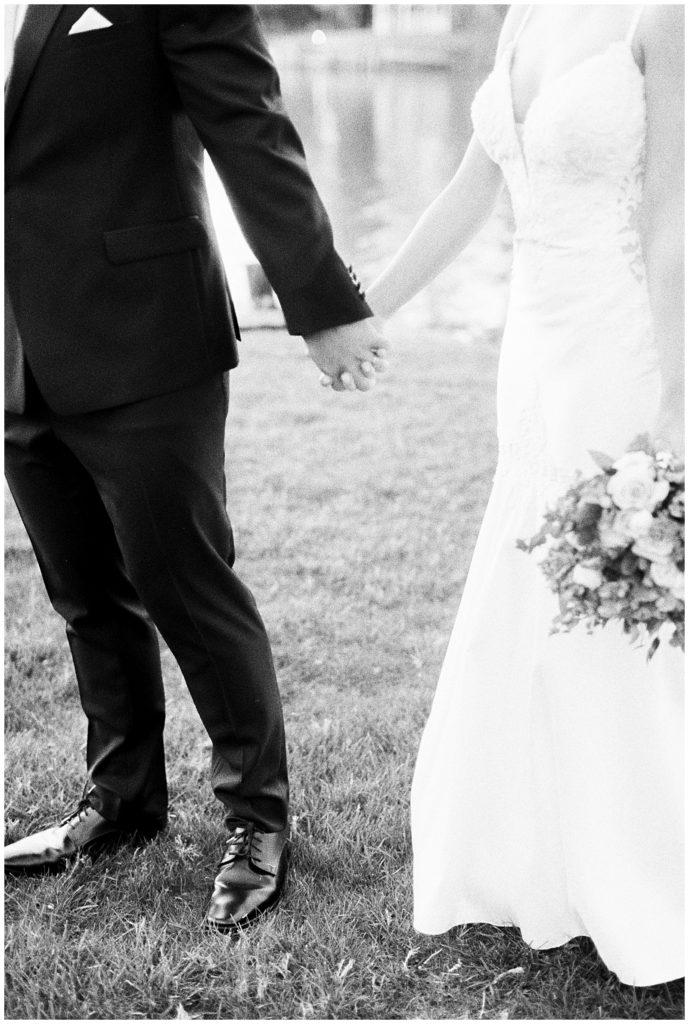 black and white film photo of married couple holding hands