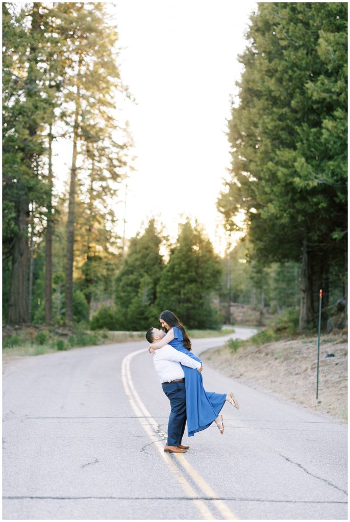 mountain sunset engagement photos of a couple dancing in the middle of an empty road