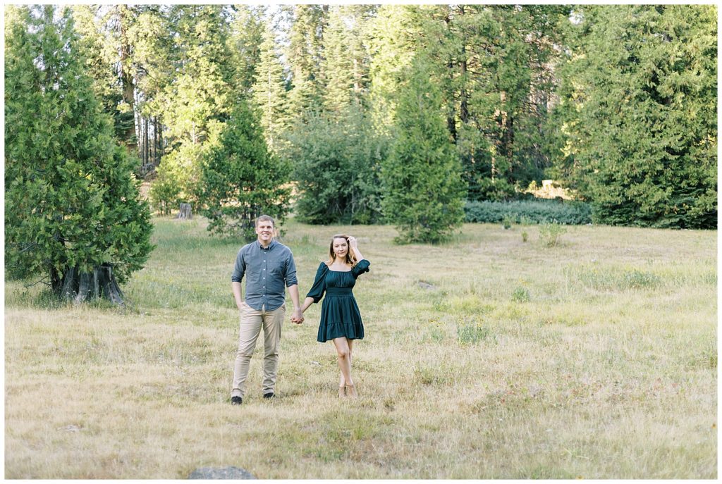 couple walking through a green grassy meadow