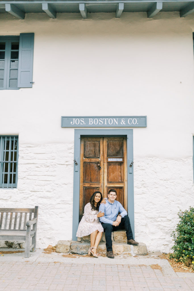 engaged couple sitting along the steps of a building in Old town Monterey by Fresno Photographer Megan Helm