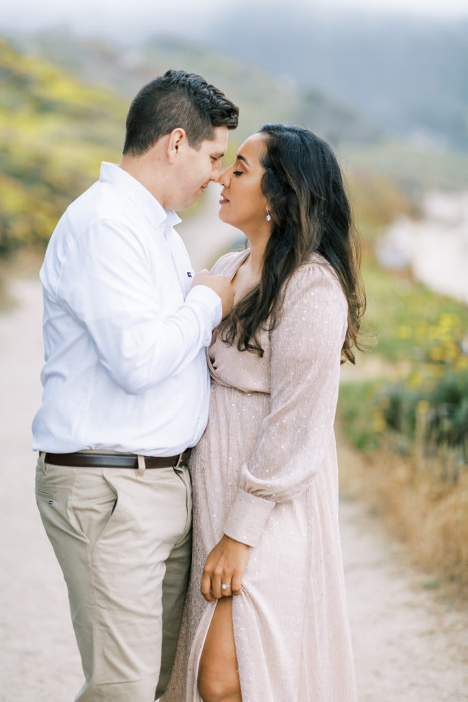 intimate moment between an engaged couple on a foggy day by the beach in carmel for engagement photos