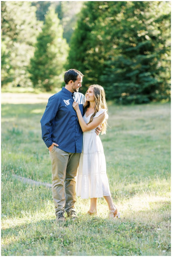 man and woman looking at each other and smiling while standing in a grassy meadow shaver lake photographer