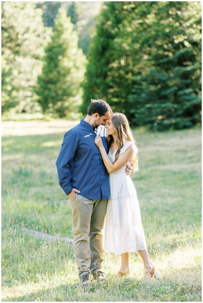 engaged couple embracing smiling wearing white and blue