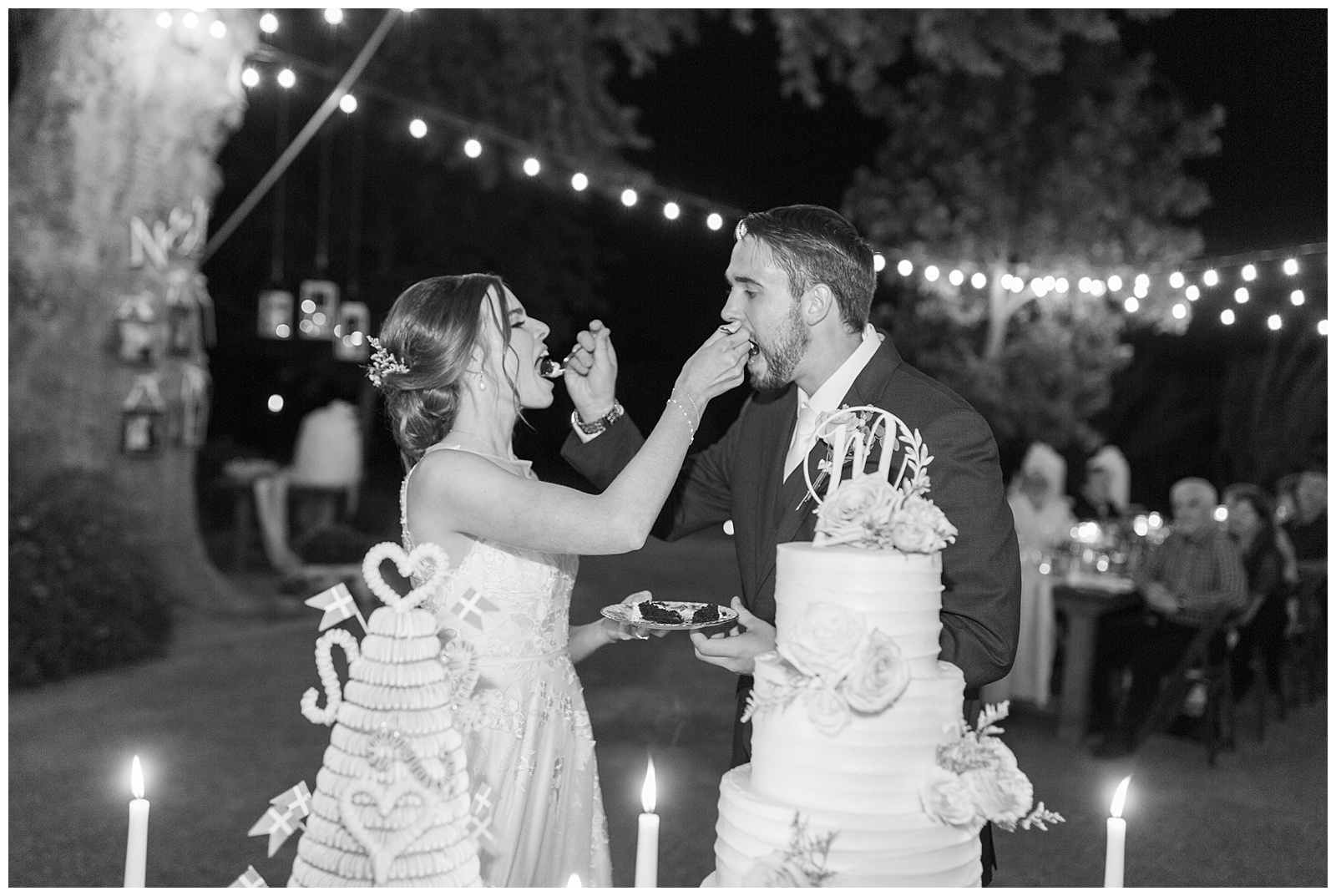 black and white image bride and groom feeding each other chocolate wedding cake
