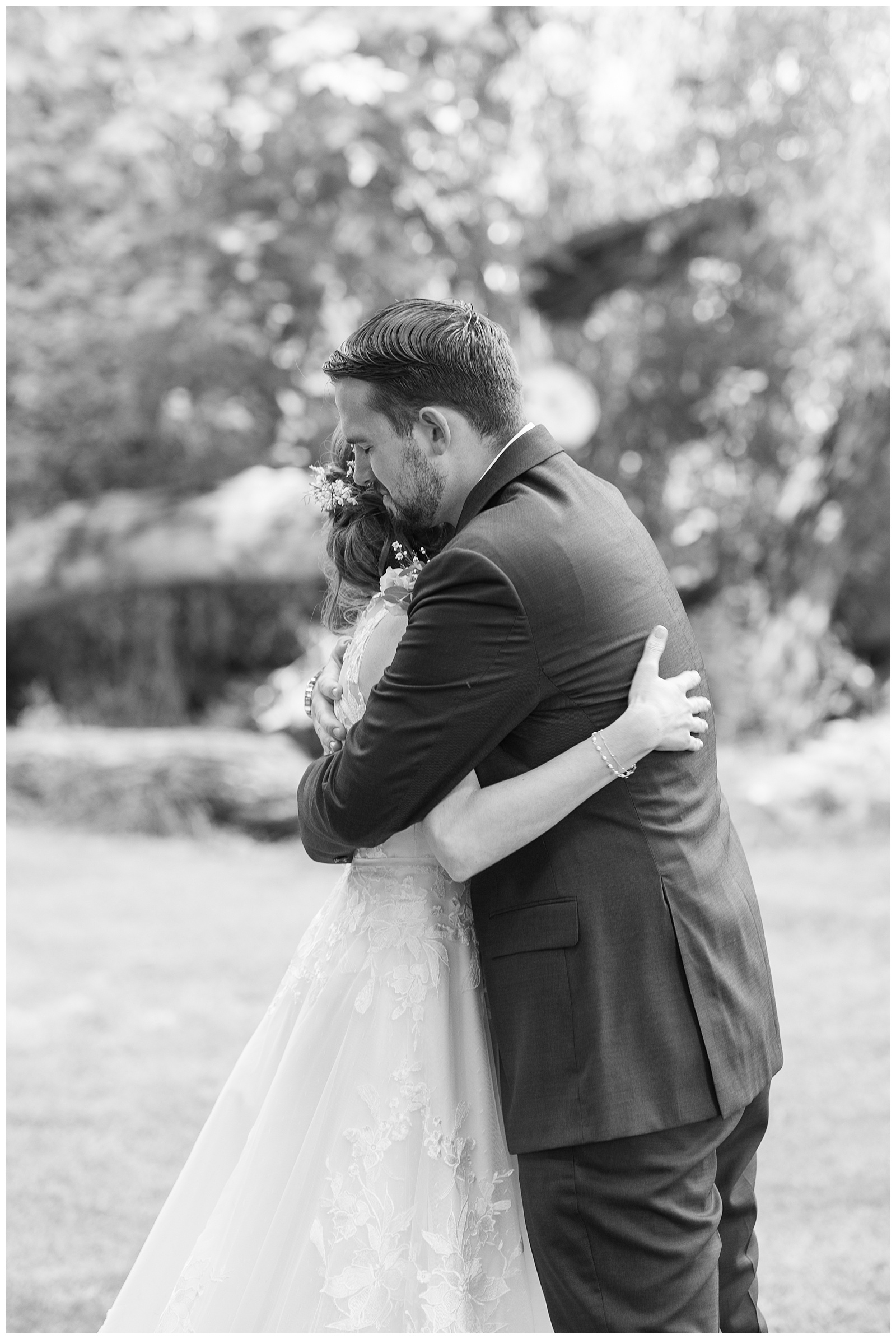 black and white image groom hugging bride during wedding first look