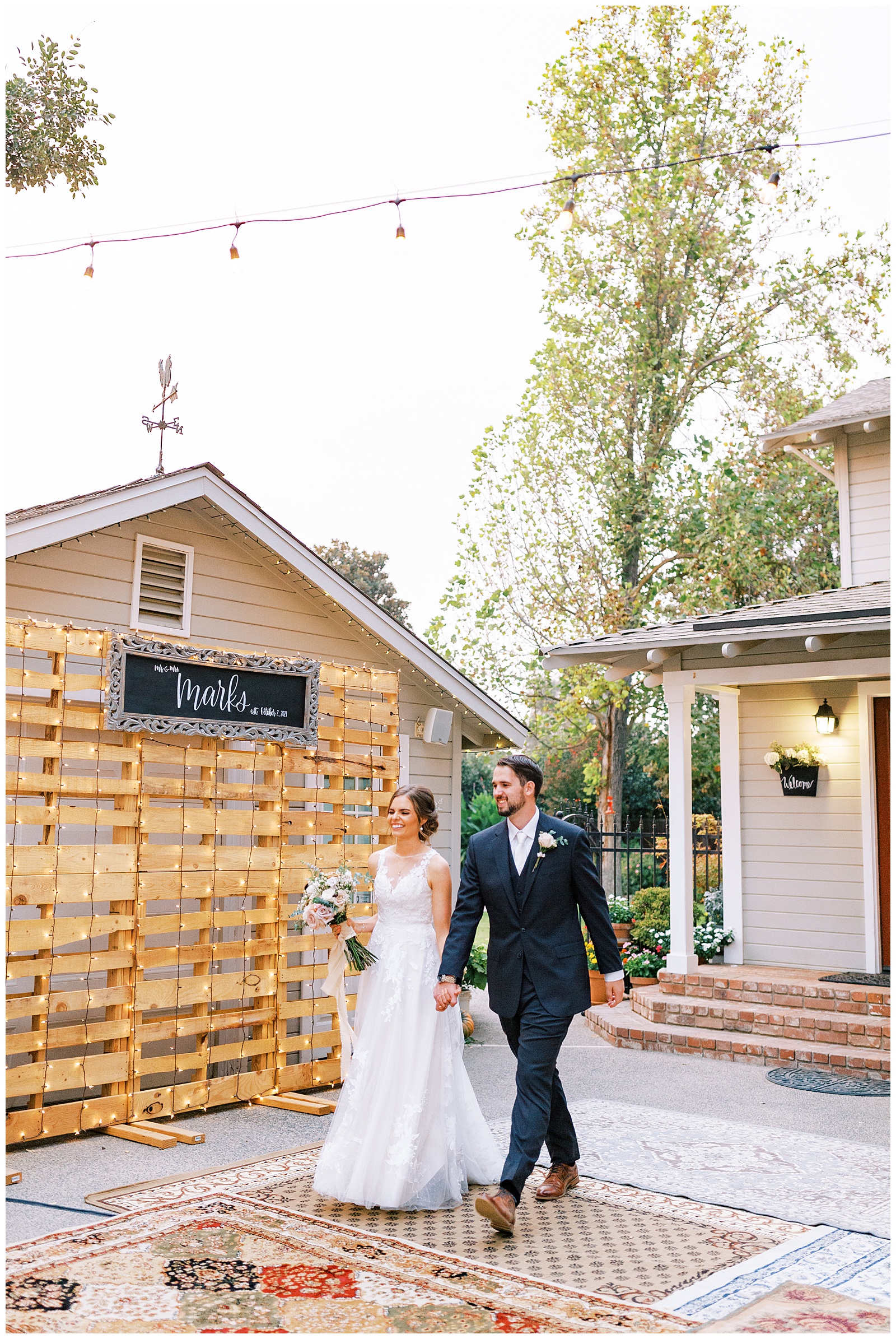 bride and groom holding hands smiling walking into backyard reedley wedding reception
