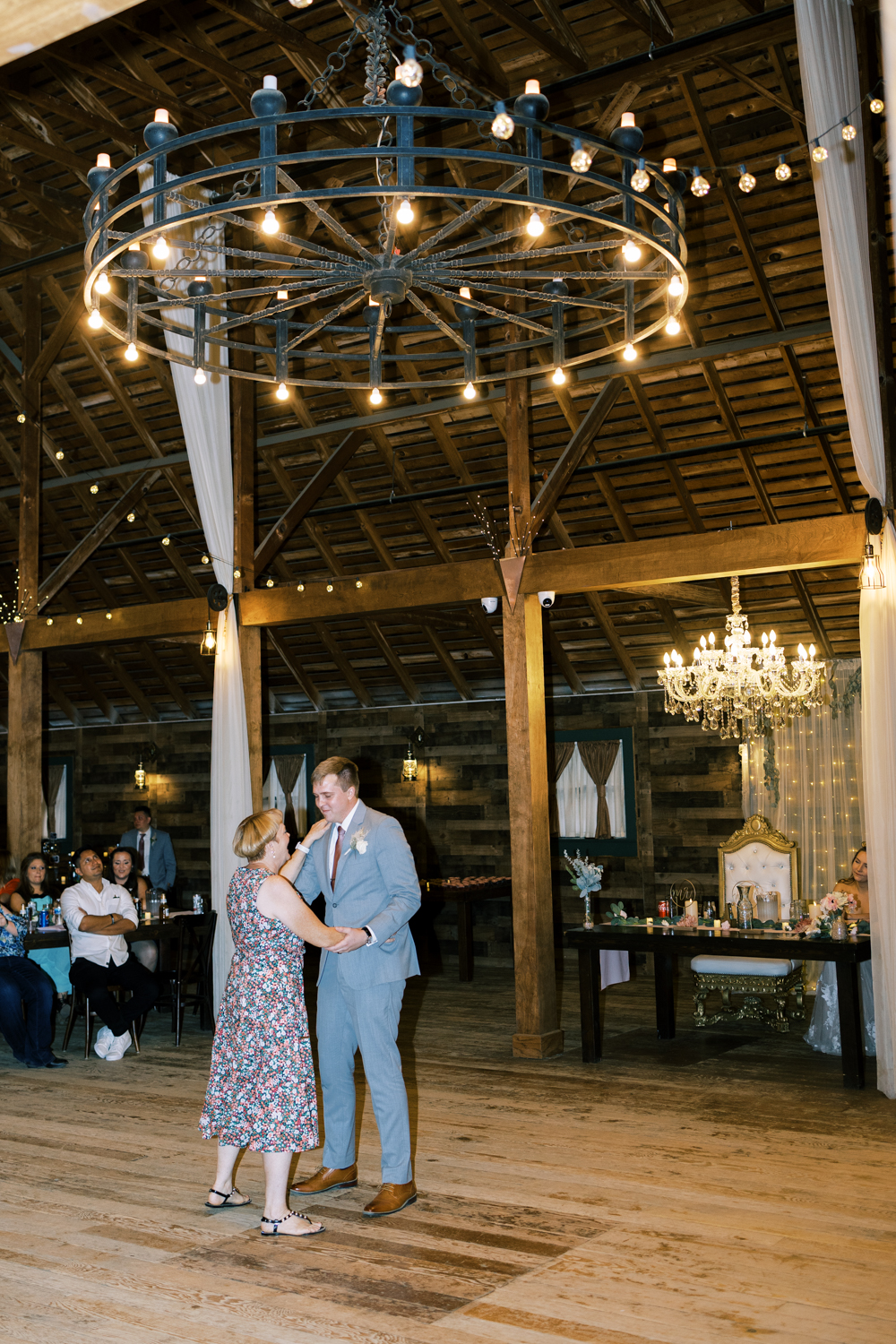 groom dancing with mother during barn wedding ceremony