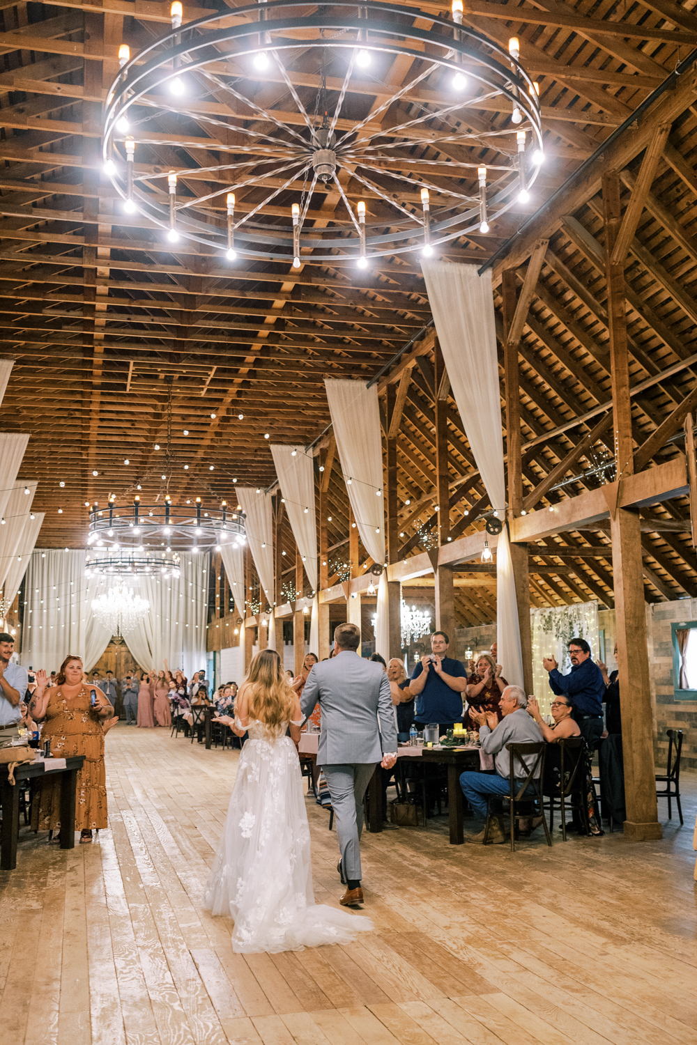 bride and groom walking into barn wedding reception at springville ranch