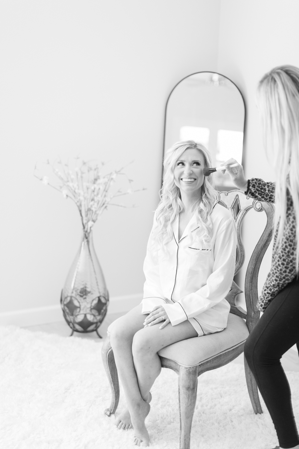 black and white photo of bride getting makeup done on wedding day