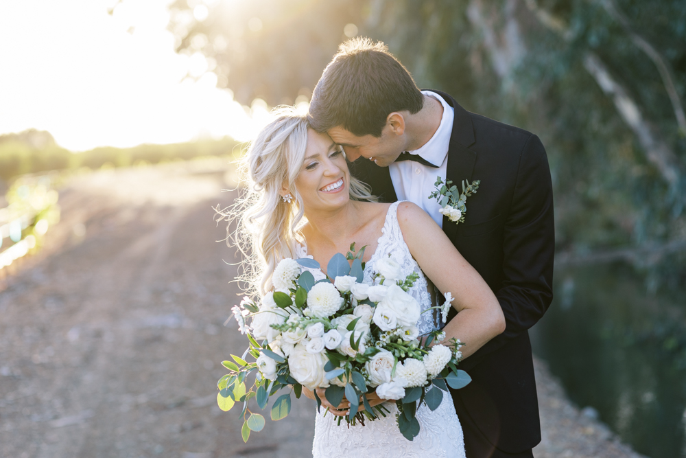 groom nuzzling brides cheek and smiling sunset behind by fresno wedding photographer megan helm