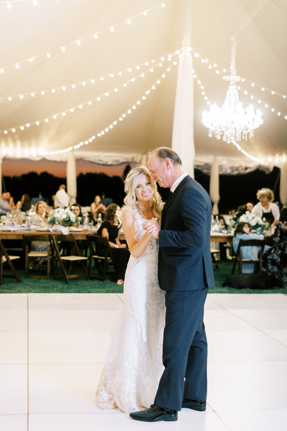 bride dancing with her father under tent at wedding reception