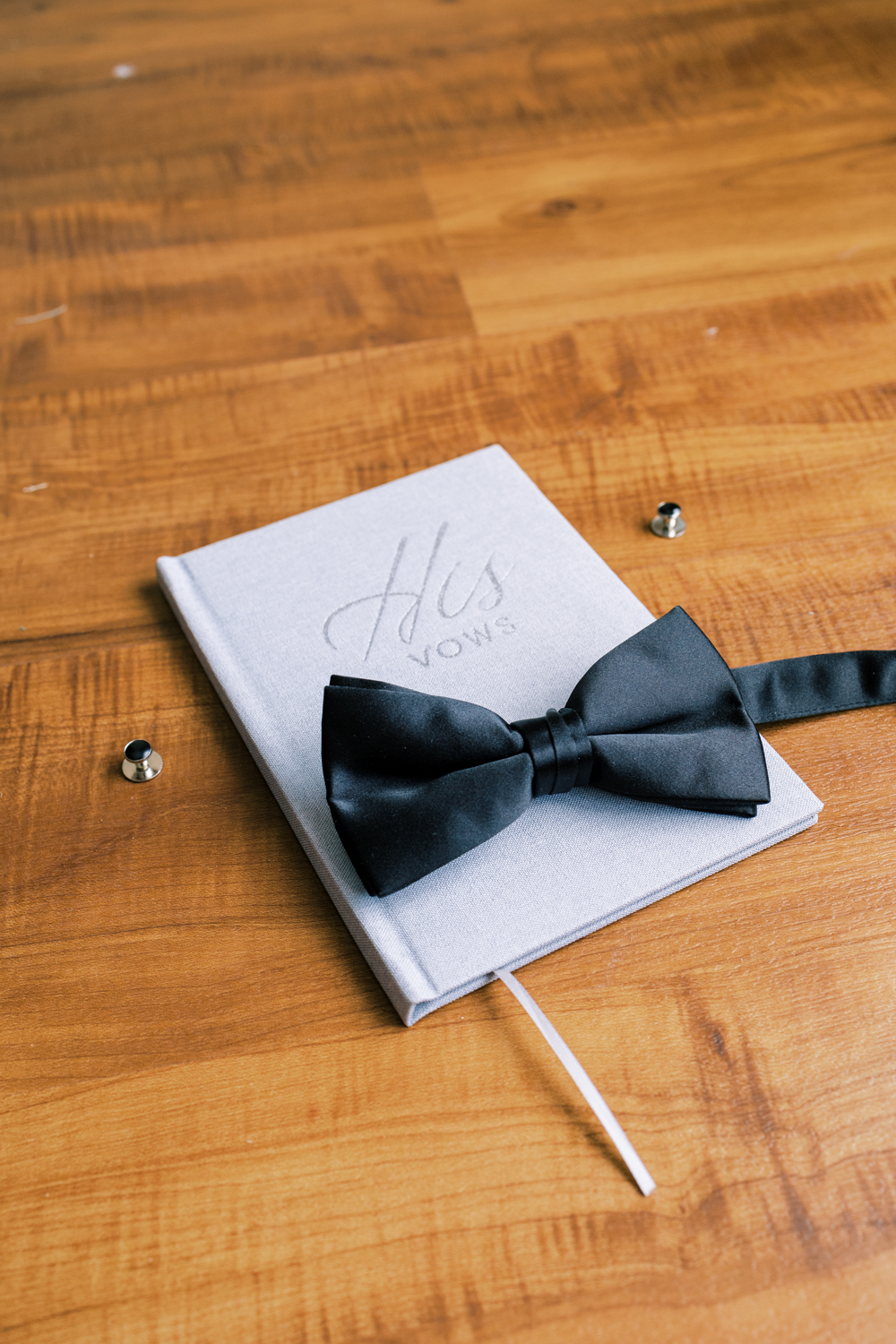 grooms vow book with bow tie and cuff links