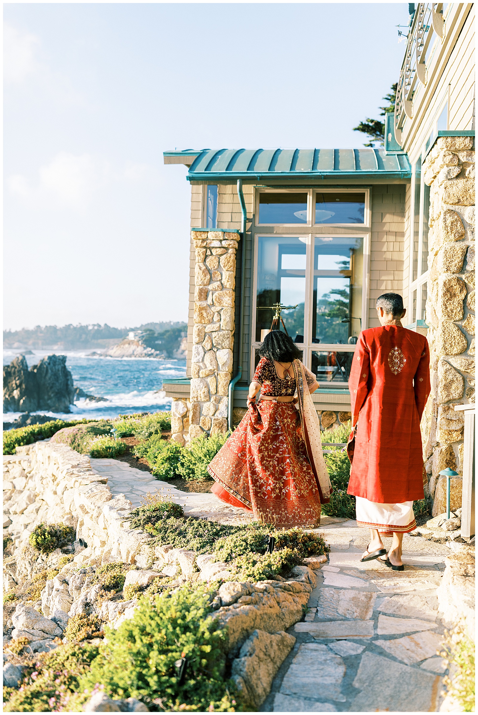 bride and groom walking along stone walk way cliffside home carmel-by-the-sea
