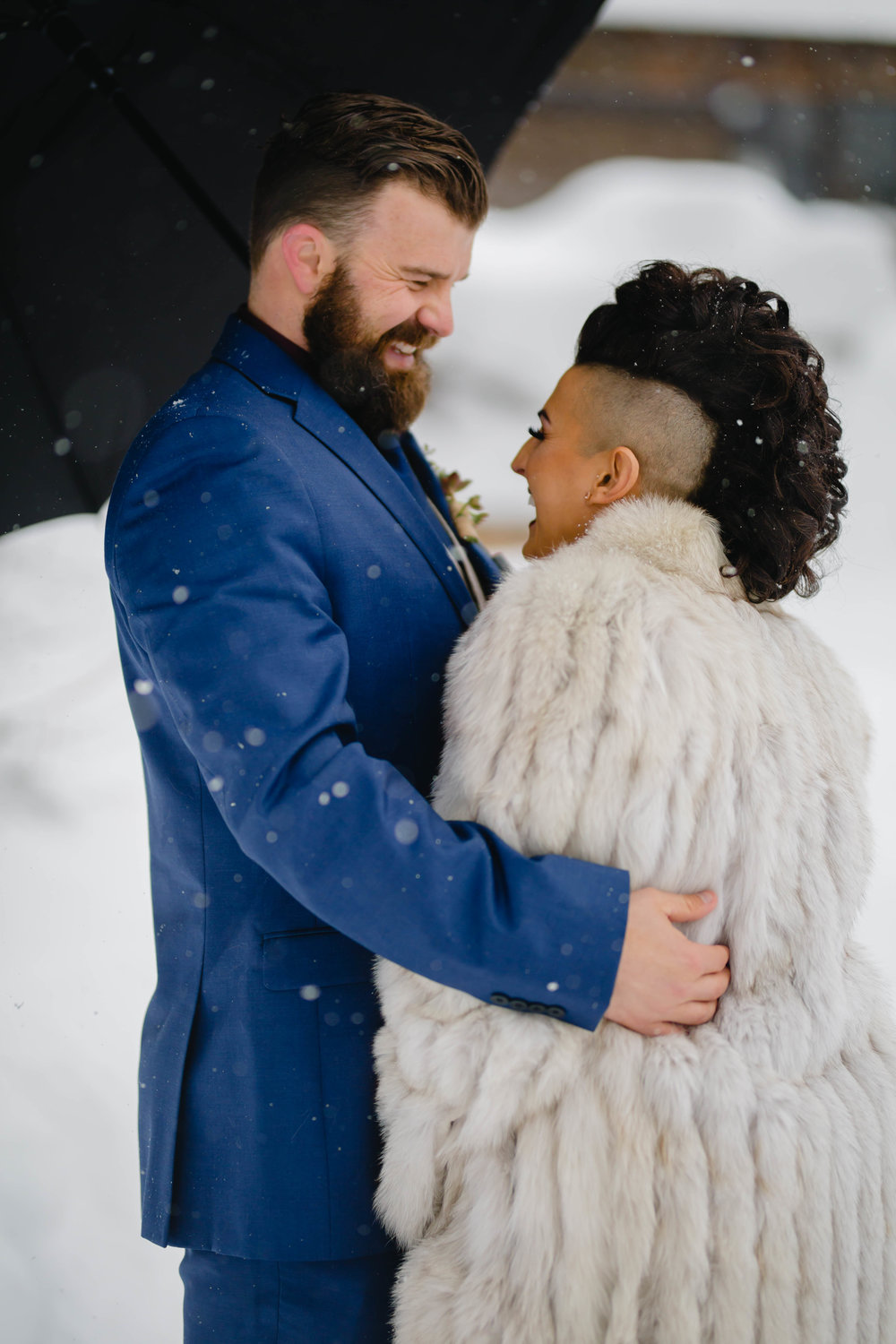 candid photo of the bride and groom during their first look for snowy wedding photos