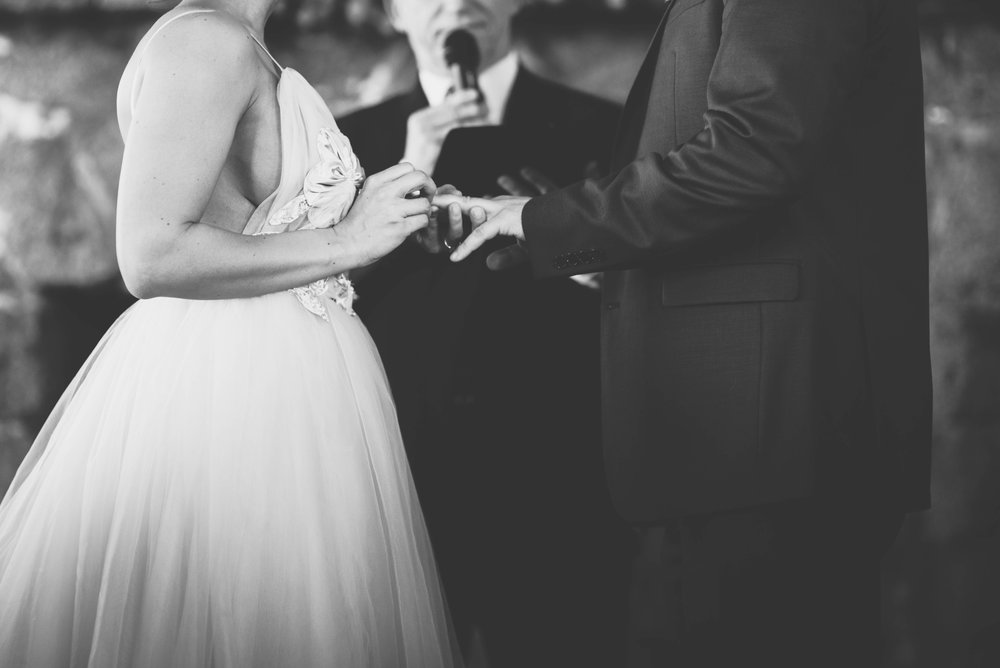 black and white photo of the bride giving the groom his wedding ring