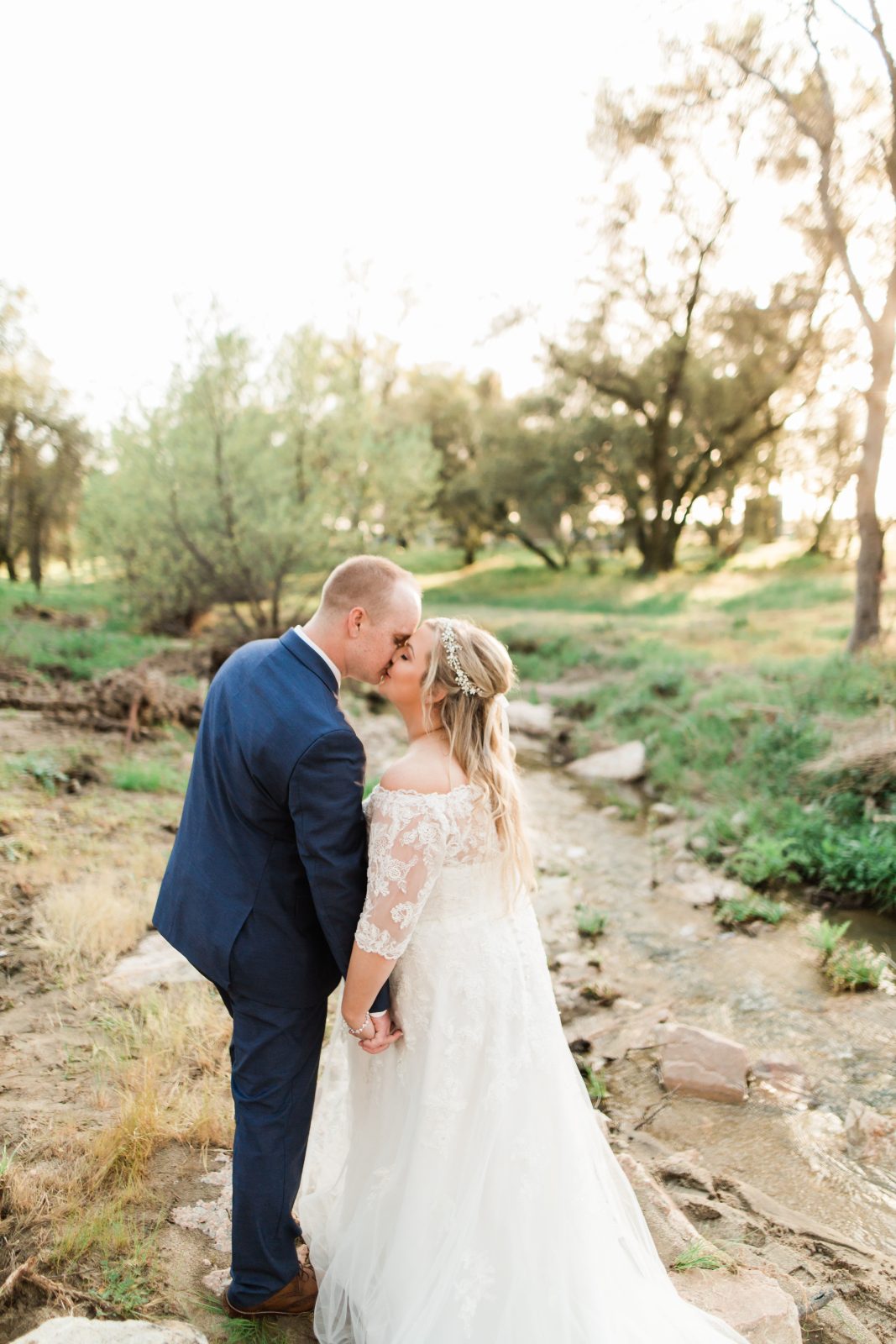 bride and groom kissing at sunset by a creek in auberry california