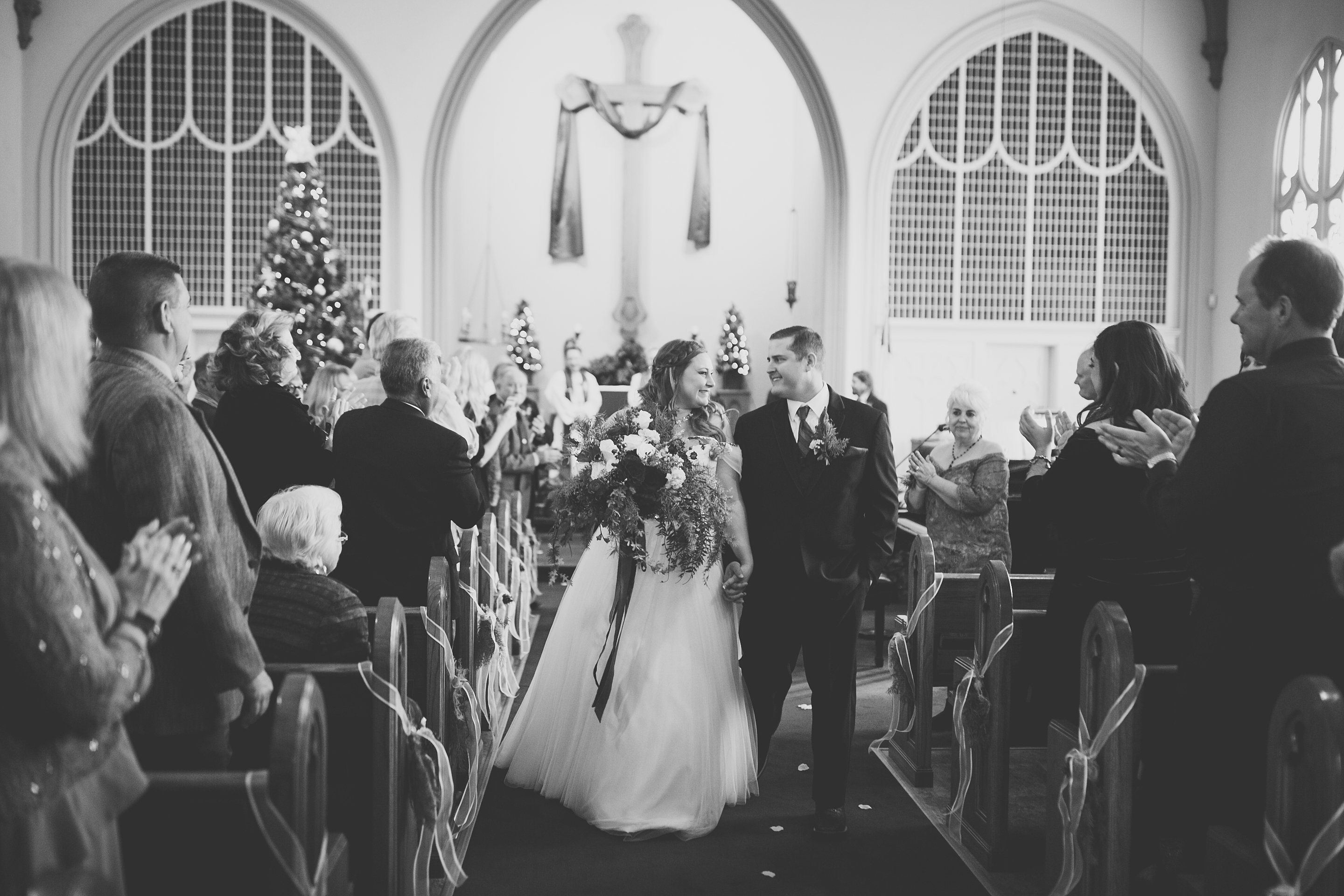 bride and groom walking out of the church at a christmas wedding